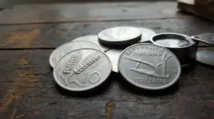 Vecchie monete italiane da 10 lire con la spiga e l’aratro su un tavolo di legno