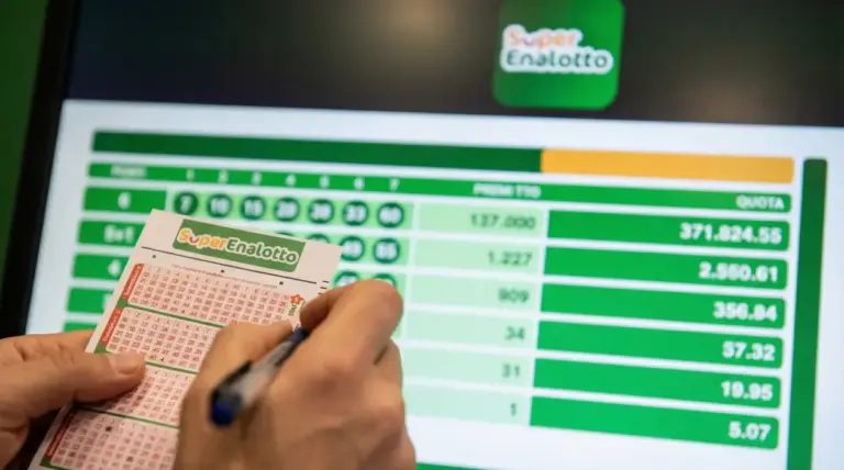Una persona compila una schedina del Superenalotto davanti a uno schermo con i risultati